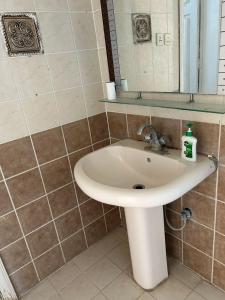 ein Badezimmer mit Waschbecken und Spiegel in der Unterkunft مسرة in Quai