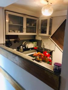 una cocina con armarios blancos y un fregadero con flores en la encimera en Thalpe sea sun villa, en Unawatuna 37 fotos más