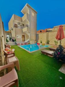 a house with a green yard with a swimming pool at King house hotel dahab in Dahab