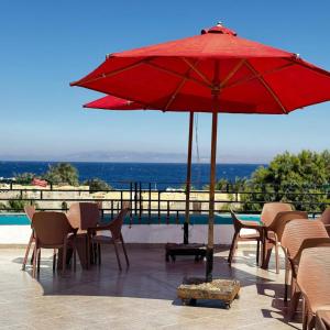 a red umbrella sitting on top of a patio at King house hotel dahab in Dahab