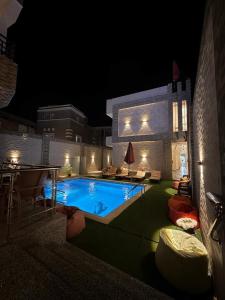 a swimming pool in a backyard at night at King house hotel dahab in Dahab +4 photos