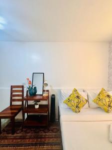 a living room with a white couch and a side table at La Casita Feliz in Puerto Princesa City