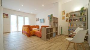 a living room with an orange couch and a book shelf at Casa Florinda in Monterotondo