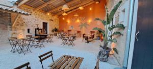 a patio with tables and chairs in a building at Mazet en provence pour 4, piscine chauffée privée, jardin clos privé, barbecue, chiens admis in Sainte-Jalle