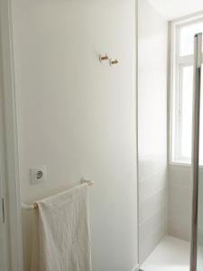 a white bathroom with a shower and a towel at AREAS NEGRAS- Apartamento centro de Cedeira. in Cedeira
