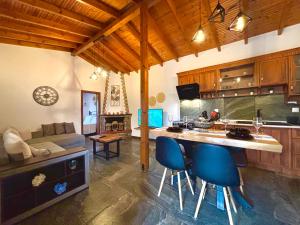 a kitchen with a counter and some blue chairs at MK Rustic Stays in Neos Marmaras