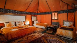 a bedroom with two beds in a tent at Comfort Luxury Camp in Merzouga +128 photos