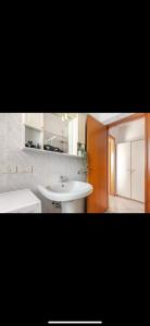 a bathroom with a white sink and a door at Appartamento sul Porto di Bellaria Igea Marina in Bellaria-Igea Marina