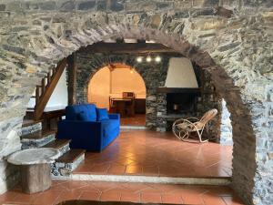 a living room with a blue couch and a stone wall at Villa Franca Nature Holidays in Rezzo