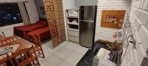 a kitchen with a refrigerator and a table and a dining room at LOFT Privado próx Garten Shopping-Universidades in Joinville