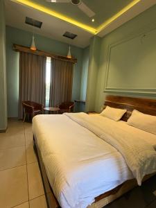 een slaapkamer met een groot bed en een eetkamer bij Pratap Mahal by Vihasta, Udaipur in Thūr +5 foto's