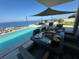 a table with food on it next to a swimming pool at Villa Lodos in Bodrum City
