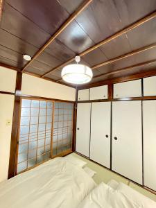 a bedroom with white cabinets and a large bed at サニーサイドホステル1号館 in Uji