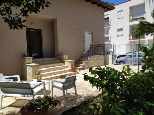 a patio with two chairs and a table in front of a building at La Rugiada-con giardino privato in Alcamo