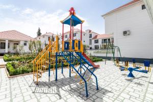 une aire de jeux avec un toboggan dans une cour dans l'établissement Magnolia Family Boutique and Spa, à İvanovka