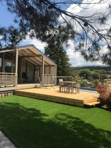 a house with a deck with a table and chairs at La Dacha Montanya in Seva
