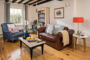a living room with a couch and a table at Trevigue Cottage in Bude