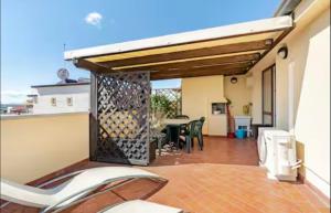 a patio with a table and chairs in a house at Attico Vista Mare 50m dal centro in Bellaria-Igea Marina