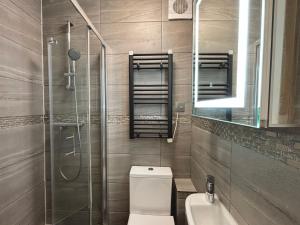 a bathroom with a toilet and a shower and a sink at The Seraphina Suite - Chelsea in London +16 photos