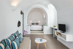 a living room with a couch and a bed at Villa Irini Fira - Adults Only in Fira