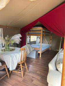 una camera con tavolo e un letto in tenda di Luxury tree top glamping safari tent a Killarney