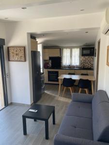 a living room with a couch and a table and a kitchen at GRIMAUD-Maison 4 Pers - Piscine in Grimaud