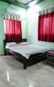 a bed in a room with red curtains at Bachhav Farm House in Katrab