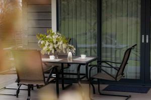a table with two chairs and a vase with flowers at Greenland House in Cēsis
