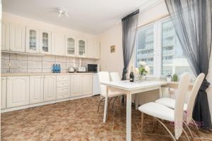 a kitchen with white cabinets and a table and chairs at Your Holidays Campingowa in Międzyzdroje