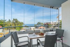 a balcony with a table and chairs and a view of the ocean at Your Holidays Campingowa in Międzyzdroje