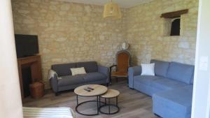 a living room with two blue couches and a table at Au petit moulin in Issigeac