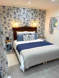 a bedroom with a bed with blue and white wallpaper at La roulotte du Manoir 1900 in La Ferté-Gaucher +28 photos