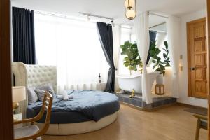 a bedroom with a bed and a tub in a window at AMIGO Luxury Palace- Cạnh Chợ Đêm Đà Lạt in Da Lat