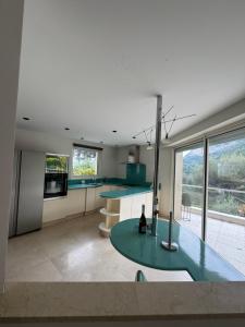 a kitchen with a green table and some windows at Villa just next to Monaco Jacuzzi in Roquebrune-Cap-Martin