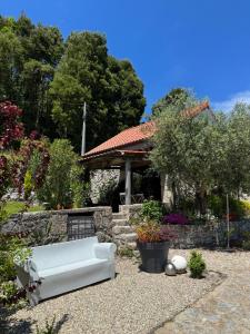a white couch sitting in the middle of a garden at Quinta da Lembrança in Arcos de Valdevez