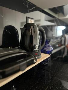 a tea kettle is sitting on a shelf next to a toaster at FOUR L's in Arape-Rashbulli