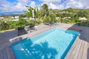 莱特鲁瓦西莱Villa KANOA - T2- classé 4 étoiles - Vue Mer - Piscine - SPA的游泳池位于带椅子的木甲板上
