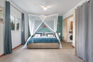 莱特鲁瓦西莱Villa KANOA - T2- classé 4 étoiles - Vue Mer - Piscine - SPA的带天篷床的卧室