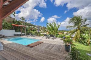 莱特鲁瓦西莱Villa KANOA - T2- classé 4 étoiles - Vue Mer - Piscine - SPA的房屋旁的木甲板上的游泳池