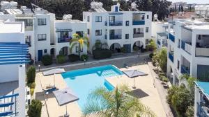 an apartment with a swimming pool and some white buildings at paphos pool view gem - cozy 1 bed Apartment in Paphos