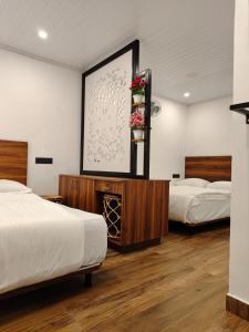 a room with two beds and a picture on the wall at Birdwing Cottage, Munnar in Munnar
