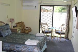 Schlafzimmer mit einem Bett, einem Tisch und Stühlen in der Unterkunft Sun Plaza Motel - Mackay in Mackay