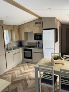 a kitchen with white cabinets and a wooden floor at 4 persoons chalet HZ 22 in Lauwersoog