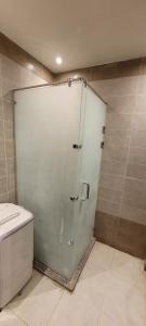 a glass shower door in a bathroom with a toilet at Hotel Room in Princess Resort With Beach Acces & Free Wi-fi I Near Air port in Hurghada