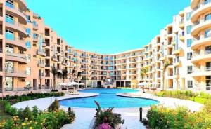 a large apartment building with a large swimming pool at Hotel Room in Princess Resort With Beach Acces & Free Wi-fi I Near Air port in Hurghada