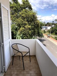 a chair on a balcony with a view of a street at Apt H - Beach Village in Olhos de Água