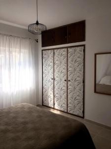 a bedroom with a bed and a window at Apt H - Beach Village in Olhos de Água