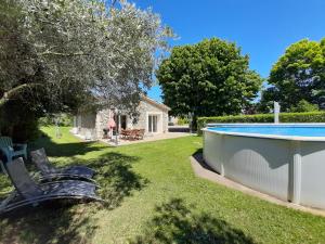a yard with a swimming pool and a house at l esquisse in Cléon-dʼAndran