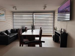 un salon avec une table et un canapé dans l'établissement Edificio Claro Solar - Moderno Apartamento Centro Temuco 2D2B Parking, à Temuco 3 autres photos