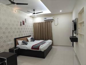a bedroom with a bed and a television in it at Rapti Inn in Gorakhpur